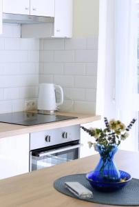 a kitchen with a blue vase on a table at Cloé Apartman in Szeged