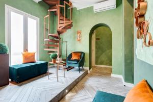 a living room with green walls and a spiral staircase at Ripetta Luxurious Suites in Rome