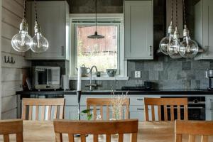 a kitchen with white cabinets and a table with chairs at Alpstigen 10B - Newly built sports cottage with lovely views (lower apt) in Järvsö