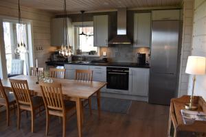 cocina con mesa de madera y nevera en Alpstigen 10B - Newly built sports cottage with lovely views (lower apt), en Järvsö