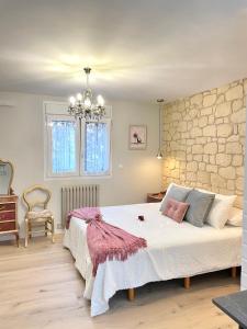 1 dormitorio con 1 cama grande y pared de piedra en Apartamentos LA SOMERA, en Alhama de Aragón