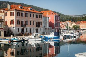 un groupe de bateaux amarrés dans un port avec des bâtiments dans l'établissement Ancora Faros, à Stari Grad