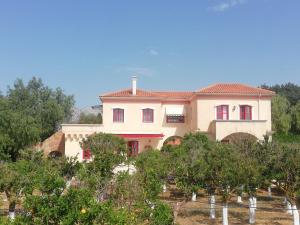 una grande casa in cima a una collina con alberi di BELLA CISTERNA a Kambos