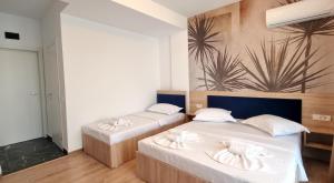 Zimmer mit 2 Betten und weißer Bettwäsche in der Unterkunft Vila Natalia in Eforie Nord
