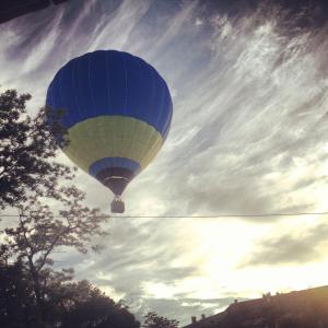 a blue hot air balloon in a cloudy sky at Guesthouse Grand Canyon in Kamianets-Podilskyi