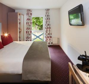 Cette chambre comprend un grand lit et une fenêtre. dans l'établissement Hotel Aigue Marine, à Tréguier