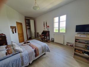 a bedroom with a bed and a flat screen tv at la source de bougival in Bougival