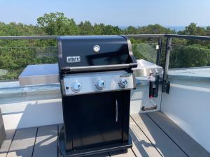 a grill on the deck of a boat at Penthouse am Südstrand - Dachterrasse mit Meerblick und Gasgrill, Klimaanlage, Luxus-Design-Apartment, 2 Minuten zum Strand, Strandkorb in Binz