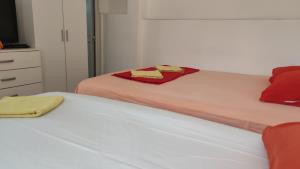 a bedroom with two beds with red and yellow towels at Guest's house ''Lindi&Roni'' in Ulcinj