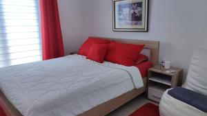 a bedroom with a bed with red pillows at Guest's house ''Lindi&Roni'' in Ulcinj