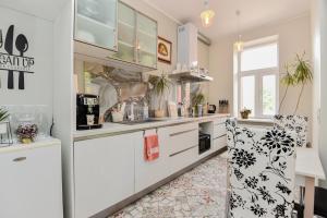 a kitchen with white cabinets and a refrigerator at Hotel Jugend with Self Check-in in Liepāja