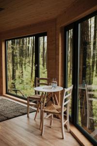 a table and chairs on the porch of a cabin at Dziki Las - domki na drzewach in Miłomłyn