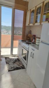 a kitchen with a stove and a refrigerator at Guest's house ''Lindi&Roni'' in Ulcinj
