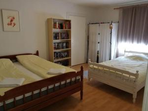 1 dormitorio con 2 camas y estante para libros en Old village school, en Kolkontaipale