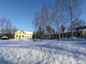a snow covered yard with a building and a picnic table at Old village school in Kolkontaipale