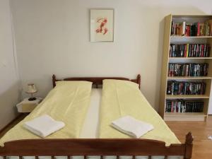 a bed with a yellow blanket on it with a book shelf at Old village school in Kolkontaipale +38 photos