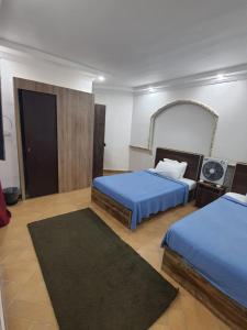 a hotel room with two beds and a mirror at Borg Barka - Families Only in Alexandria