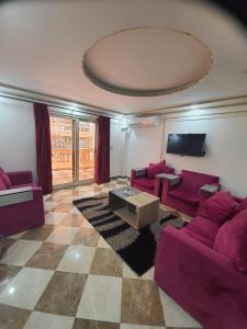 a living room with purple couches and a tv at Borg Barka - Families Only in Alexandria +101 photos