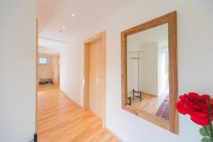 a mirror on a wall next to a hallway at Apartment Eisl in Ramsau am Dachstein