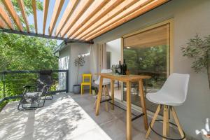 eine Terrasse mit einem Tisch und Stühlen auf einer Terrasse in der Unterkunft Peroj's Green Oasis - Holiday home in Peroj