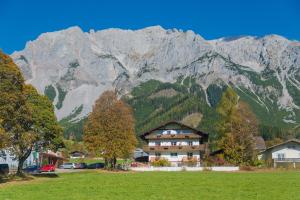 a large house in front of a mountain at Apartment Eisl in Ramsau am Dachstein