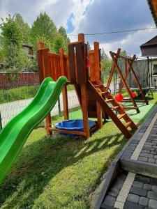 a playground with a slide in the grass at Willa Górskie Tarasy in Kościelisko