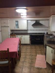 una cucina con tavolo e tovaglia rosa di Casa o Cantón a Berredo