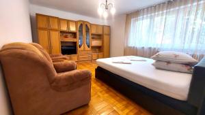 1 dormitorio con 1 cama y 1 silla en The Home, en Hunedoara