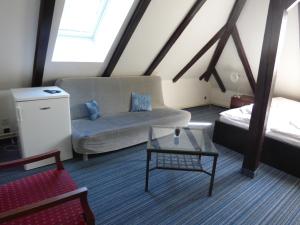 ein Wohnzimmer mit einem Sofa und einem Tisch in der Unterkunft Hotel Svornost in Prag