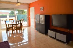 uma sala de estar com uma mesa de jantar e uma televisão em Villa Cardona Tres Calas em Les tres Cales