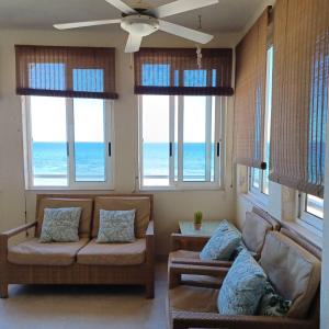 a living room with a couch and chairs and windows at Agua Marina in Arenales del Sol