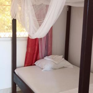a bed in a room with a window at MUNDO GUEST & STUDIO APARTMENTS, MTWAPA,mombasa in Mtwapa
