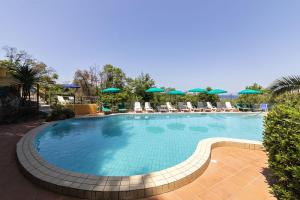 a large swimming pool with chairs and umbrellas at Bristol Hotel in Ischia