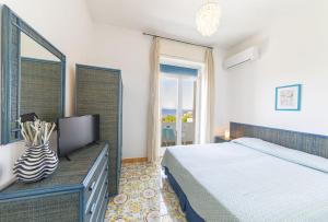 a bedroom with a bed and a tv and a window at Bristol Hotel in Ischia