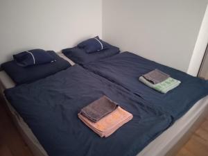 a bed with blue sheets and pillows on it at Relax apartman in Nagykanizsa
