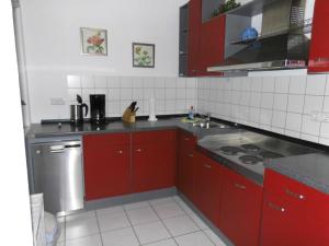 a kitchen with red cabinets and a sink at 54 Appartement Residenz Bellevue U in Zinnowitz