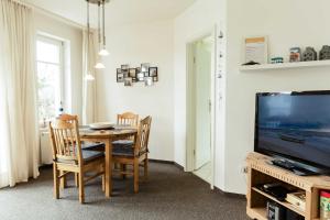 una sala da pranzo con tavolo e TV di Appartement Residenz Bellevue Whg a Zinnowitz