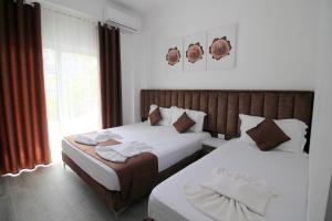 Postel nebo postele na pokoji v ubytování Hotel Vila Kapllani