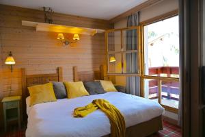 een slaapkamer met een bed met een gele deken erop bij ARC 1950 - cozy apartment with mountain view in Arc 1950