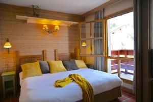 a bedroom with a bed with a yellow blanket on it at ARC 1950 - cozy apartment with mountain view in Arc 1950