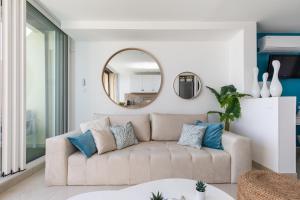 een woonkamer met een bank en een spiegel bij Blue Coral Heliopolis Naturiste in Cap d'Agde