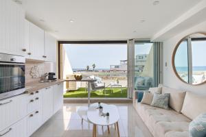 een woonkamer met een bank en een tafel bij Blue Coral Heliopolis Naturiste in Cap d'Agde