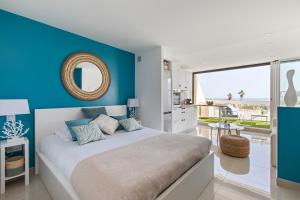sypialnia z dużym łóżkiem i niebieską ścianą w obiekcie Blue Coral Heliopolis Naturiste w Cap d'Agde