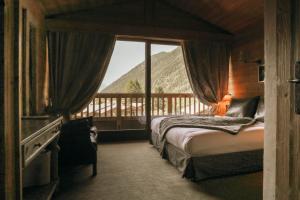 a bedroom with a bed and a view of a mountain at Les Grands Montets Hotel & Spa in Chamonix +128 photos