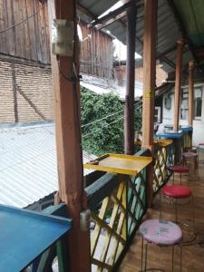 widok na werandę ze stołami i stołkami w obiekcie El Hostal w mieście Tbilisi City