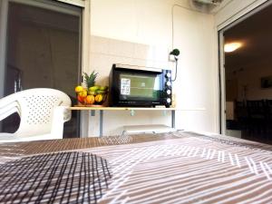 a room with a bed and a television on a shelf at Seaside BLISS in Agia Triada