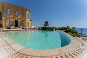 a large swimming pool in front of a building at Villa Mosca Charming House in Alghero