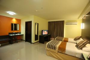 a hotel room with two beds and a flat screen tv at Panorama Hotel Bur Dubai in Dubai