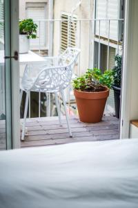 a white chair sitting on a porch with plants at DeBlox living - Ibn Gabirol Apartments in Tel Aviv