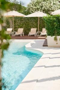 a swimming pool with chairs and umbrellas at Hotel Admiral in Budva